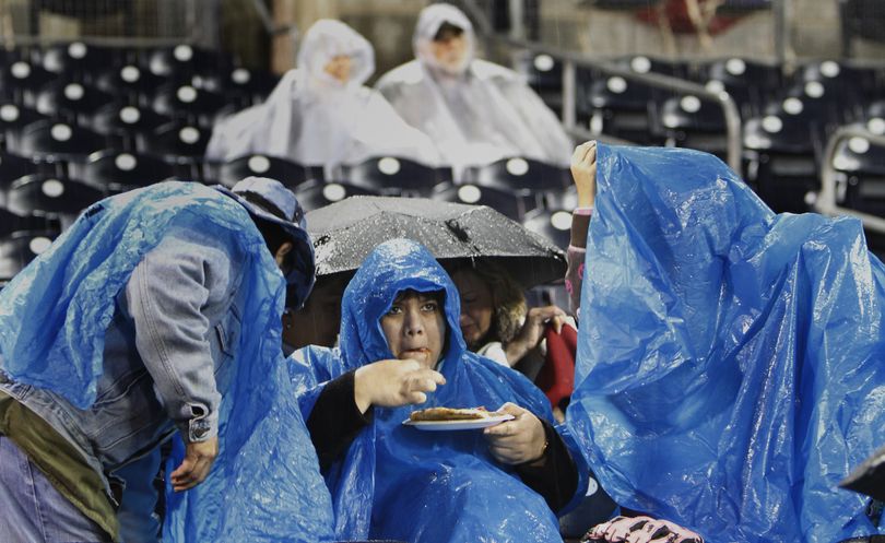 A fan gets her pizza as she waits out a rain delay during the baseball game between the San Diego Padres and Los Angeles Dodgers at Petco Park in San Diego, Friday, April 8, 2011. (Lenny Ignelzi / Associated Press)
