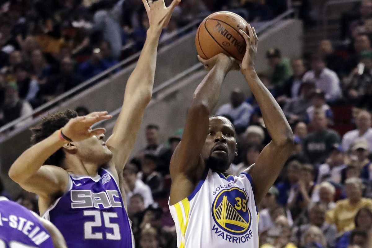 Golden State Warriors forward Kevin Durant, right, shoots as Sacramento Kings forward Justin Jackson defends during the first half of an NBA basketball preseason game Friday, Oct. 5, 2018, in Seattle. (Ted S. Warren / AP)