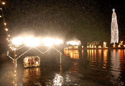
As Santa and Mrs. Claus wave from their boathouse diorama, an artificial snow storm is blown over visitors on cruise boats at the light display. 
 (Jesse Tinsley / The Spokesman-Review)