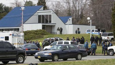 
Law enforcement personnel gather around a bank where an FBI agent was killed in a shootout with bank robbery suspects in Readington, N.J., on Thursday. 
 (Associated Press / The Spokesman-Review)