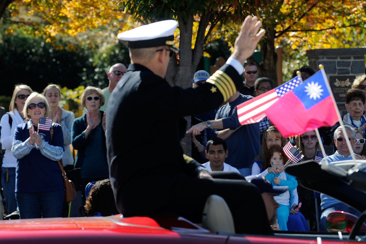 Crowds wave to Navy Capt. Jim Minta as he participates in the 31st annual Veterans Day Parade in downtown Atlanta, Saturday, Nov. 10, 2012. (David Tulis / Fr170493 Ap)
