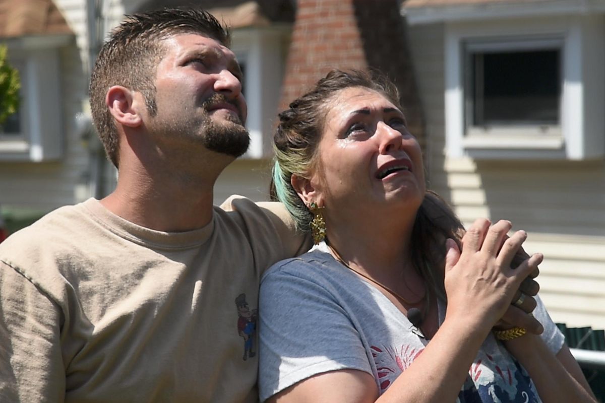 Branden Rosen, representing Free Handyman for Disabled Veterans, and Tina Barritt, a disabled Navy veteran, watch the American flag wave atop a flagpole the volunteer organization installed in Barritt’s front yard on Friday. (Colin Mulvany / The Spokesman-Review)