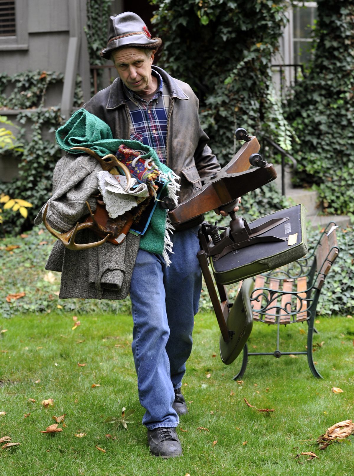 Dennis Held, owner of Area 58, gathers his finds – including a hat, clothing, blankets, office chair, antlers and a porch bench – at an estate sale on Friday in Millwood. (Dan Pelle)
