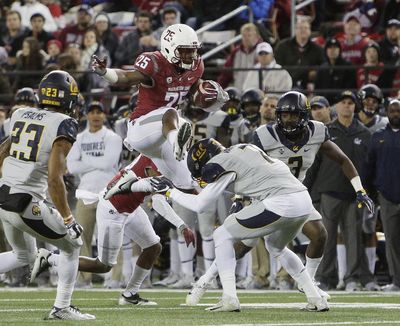 Washington State running back Jamal Morrow (25) leaps over California safety Khari Vanderbilt (7) during the first half of an NCAA college football game in Pullman, Wash. (Young Kwak / AP)