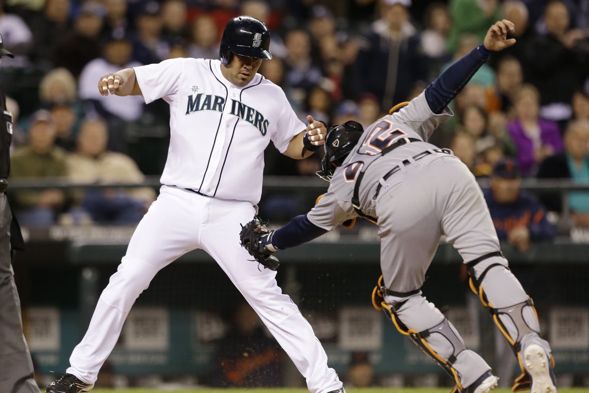 Seattle’s Kendrys Morales, left, avoids tag at home by Detroit’s Alex Avila to score in fourth inning. (Associated Press)