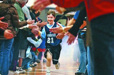 
Micah Yoppini  runs down the line as he is announced in the starting lineup  during an Upward Basketball  game at Spokane Valley Church of the Nazarene. 
 (Liz Kishimoto / The Spokesman-Review)
