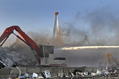 Spokane Valley firefighters pour water on  a fire in a pile of scrap metal at Dickson Iron and Metal in the 900 block of North Dyer Road on Friday. The fire sent a cloud of black smoke east over Spokane Valley.  (Christopher Anderson / The Spokesman-Review)
