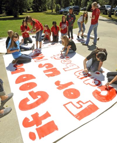 File - In this Sept. 19, 2012 file photo, Kountze High School cheerleaders and other children work on a large sign in Kountze, Texas.  Texas Attorney General Greg Abbott announced Wednesday that he is intervening in a lawsuit that cheerleaders filed against the school district. The district told the cheerleaders to stop using Bible verses at football games after the Freedom From Religion Foundation complained. (Dave Ryan / The Beaumont Enterprise)