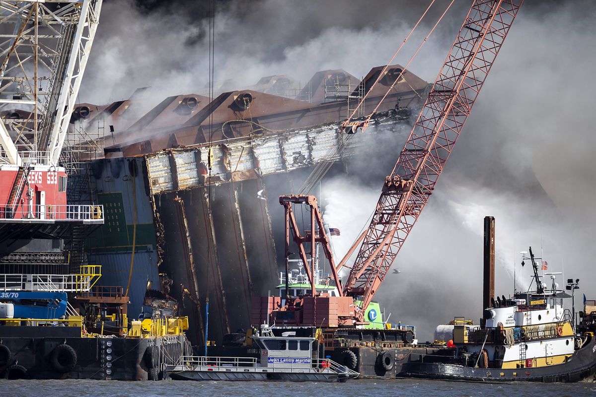 Fire fighters spray water into the cut away mid-section of the cargo vessel Golden Ray, Friday, May 14, 2021, Brunswick, Ga. The Golden Ray had roughly 4,200 vehicles in its cargo decks when it capsized off St. Simons Island on Sept. 8, 2019. Crews have used a giant gantry crane to carve the ship into eight giant chunks, then carry each section away by barge.  (Stephen B. Morton)