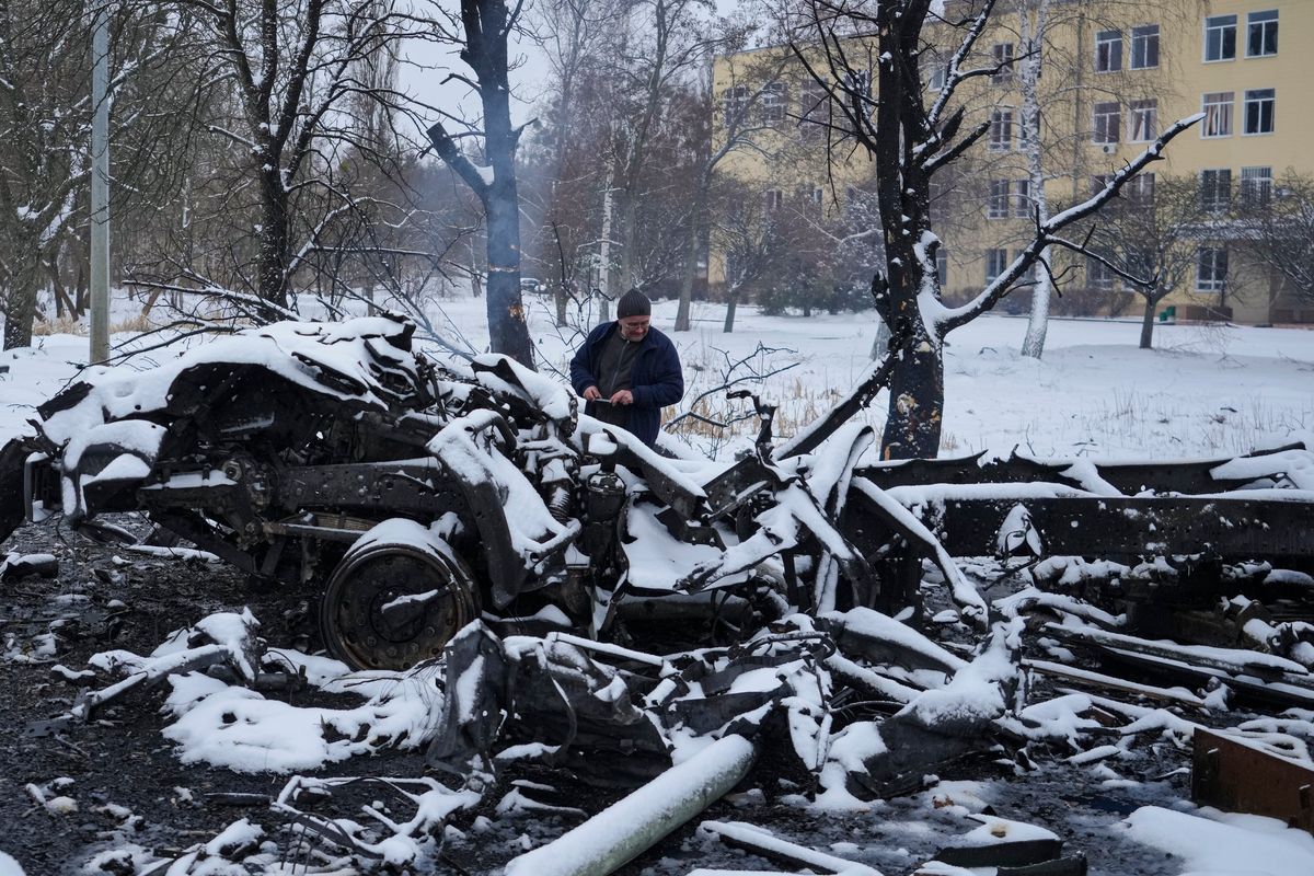 A man takes photos of still smoldering destroyed Russian military vehicles on the outskirts of Kharkiv, Ukraine, Friday, Feb. 25, 2022. Russian troops bore down on Ukraine