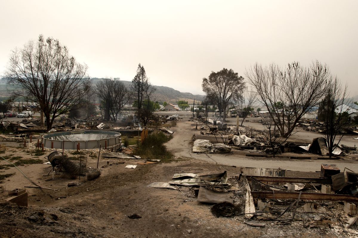 While an above-ground swimming pool survived, charred rubble marks the former locations of several residences Friday morning in Pateros. (Tyler Tjomsland)