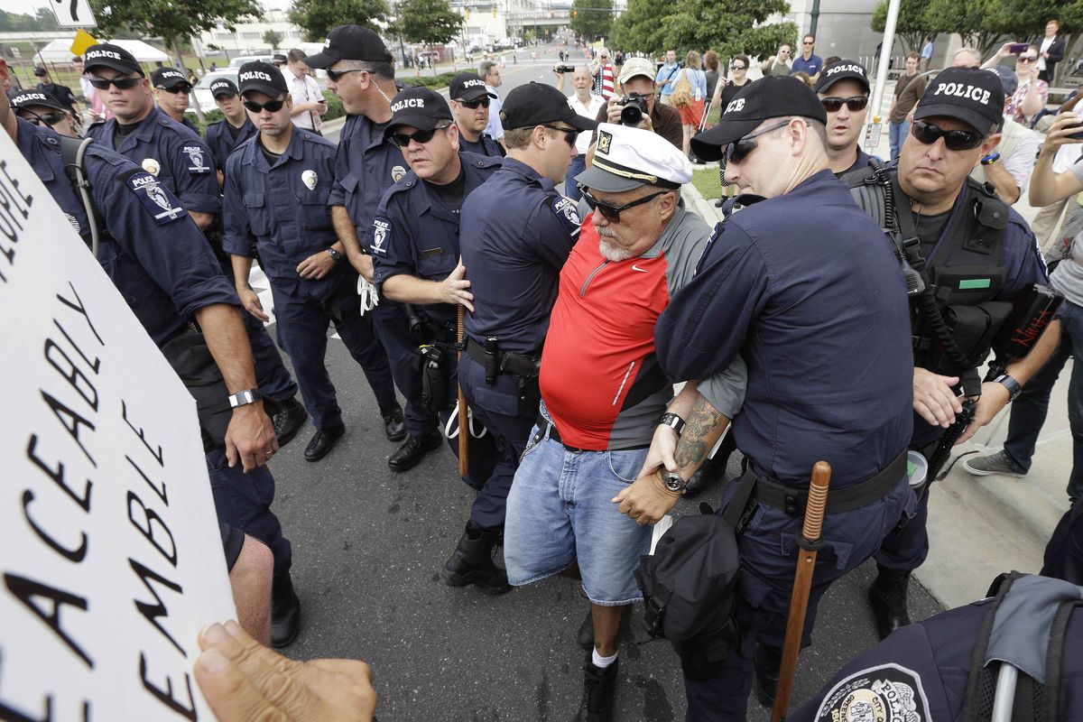 A demonstrator known only as the Captain is detained by police during an unscheduled protest march,Tuesday, Sept. 4, 2012, in Charlotte, N.C. The Democratic National Convention begins today. (Patrick Semansky / Associated Press)