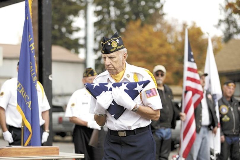 Sgt. Harold Markiewicz, a member of American Legion Post 143 in Post Falls, delivers a flag to Parkinson's family in his honor. (Young Kwak / Pacific Northwest Inlander)