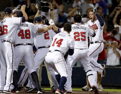 Atlanta's Freddie Freeman, right, celebrates with teammates after his homer clinched playoff berth. (Associated Press)
