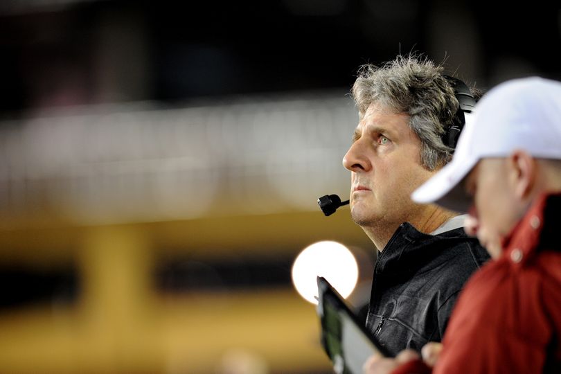 Washington State coach Mike Leach peers at the scoreboard in the first half. (Tyler Tjomsland)