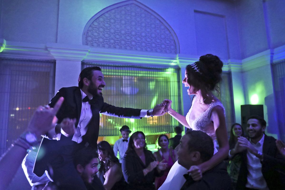 Israeli couple Noemie Azerad, right, and her husband Simon David Benhamou grasp each others hands on the shoulders of skullcap-wearing groomsmen during their wedding party at a hotel in Dubai, United Arab Emirates, Thursday, Dec. 17, 2020. For the past month, Israelis long accustomed to traveling incognito, if at all, to Arab countries, have made themselves at home in the UAE’s commercial hub.  (Kamran Jebreili/Associated Press)