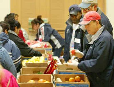 
Alcoa's Wenatchee Works employees, front to back, Robert Chambers, Pete Bennett and Larry Thomas, volunteer at a local food bank. 
 (File/Associated Press / The Spokesman-Review)