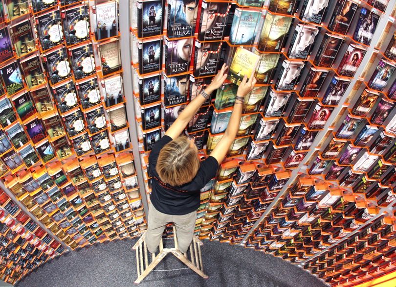 A woman adjusts books on a giant shelve at the Book Fair in Frankfurt, Germany, Tuesday, Oct. 11, 2011. The Book Fair will be opened later the day and lasts until next Sunday. (Michael Probst / Associated Press)