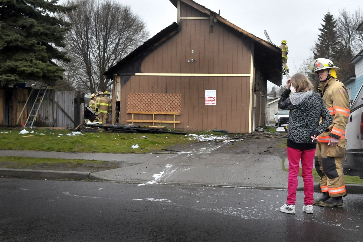 Cheryl Bratton talks with Spokane firefighters after a fire heavily damaged her apartment in the 1800 block of West Maxwell early Tuesday, April 13, 2010. (Christopher Anderson / The Spokesman-Review)