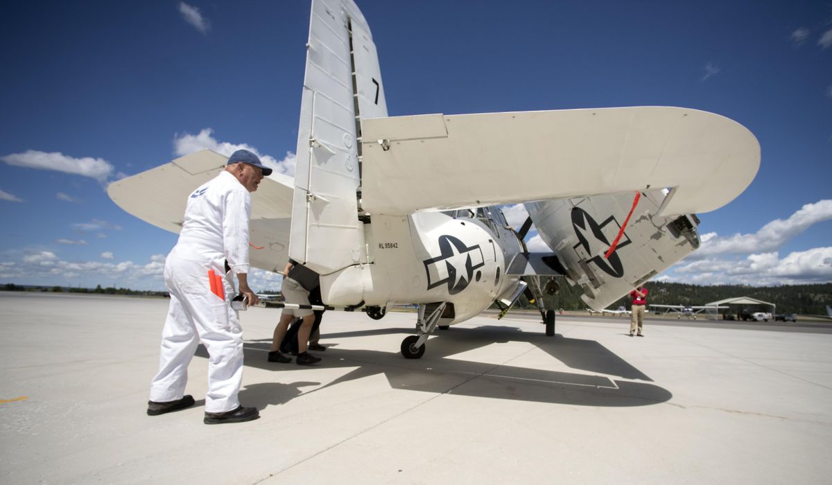 Crew chief Rob Otero, left, rotates tail of a Grumman TBF Avenger into position on the ramp at Felts Field, Friday, June 2, 2017, in preparation for Neighbor Day, a free air show at Spokanes mostly-civilian airport Saturday, June 3. (Jesse Tinsley / The Spokesman-Review)
