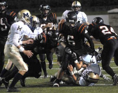 
Lewis and Clark's Vaughn Kapiko is pulled down on a punt return. 
 (Jed Conklin / The Spokesman-Review)