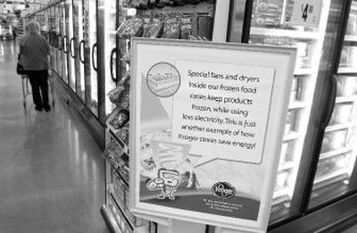 
A shopper looks at frozen foods at a Kroger's store in Loveland, Ohio. The prototype store displays signs where energy-saving features are being used. The highly competitive grocery business is getting greener as companies search for ways to cut costs and keep prices down. 
 (Associated Press / The Spokesman-Review)
