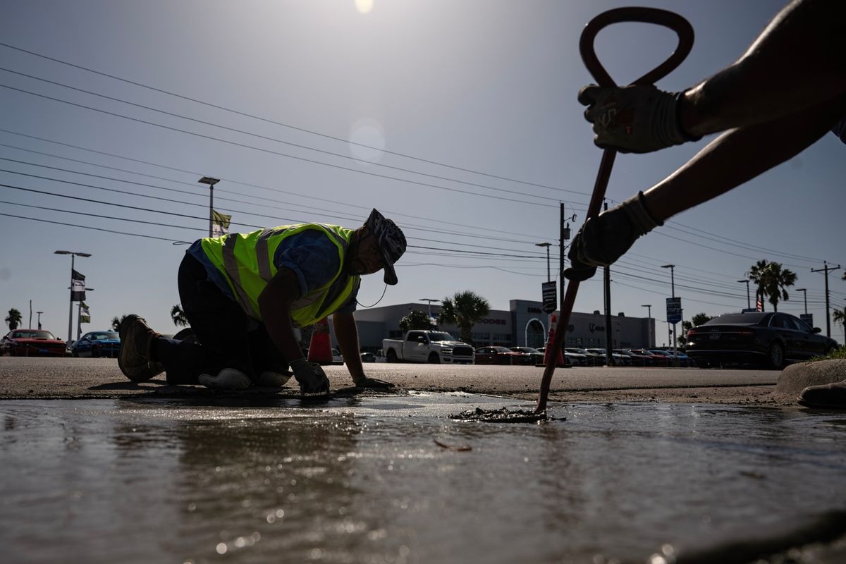 Construction workers do street repair during a heat wave in Corpus Christi, Texas, on July 20.   (Eddie Seal/Bloomberg)