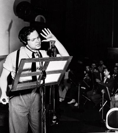 Orson Welles reads from his script during the 1938 broadcast of his radio show, “War of the Worlds.”  (Associated Press / The Spokesman-Review)