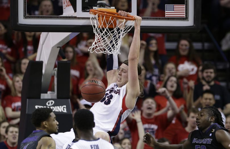 GU’s Kelly Olynyk hangs on the rim after dunking in the first half. Olynyk, with four dunks, scored 20 points. (Associated Press)