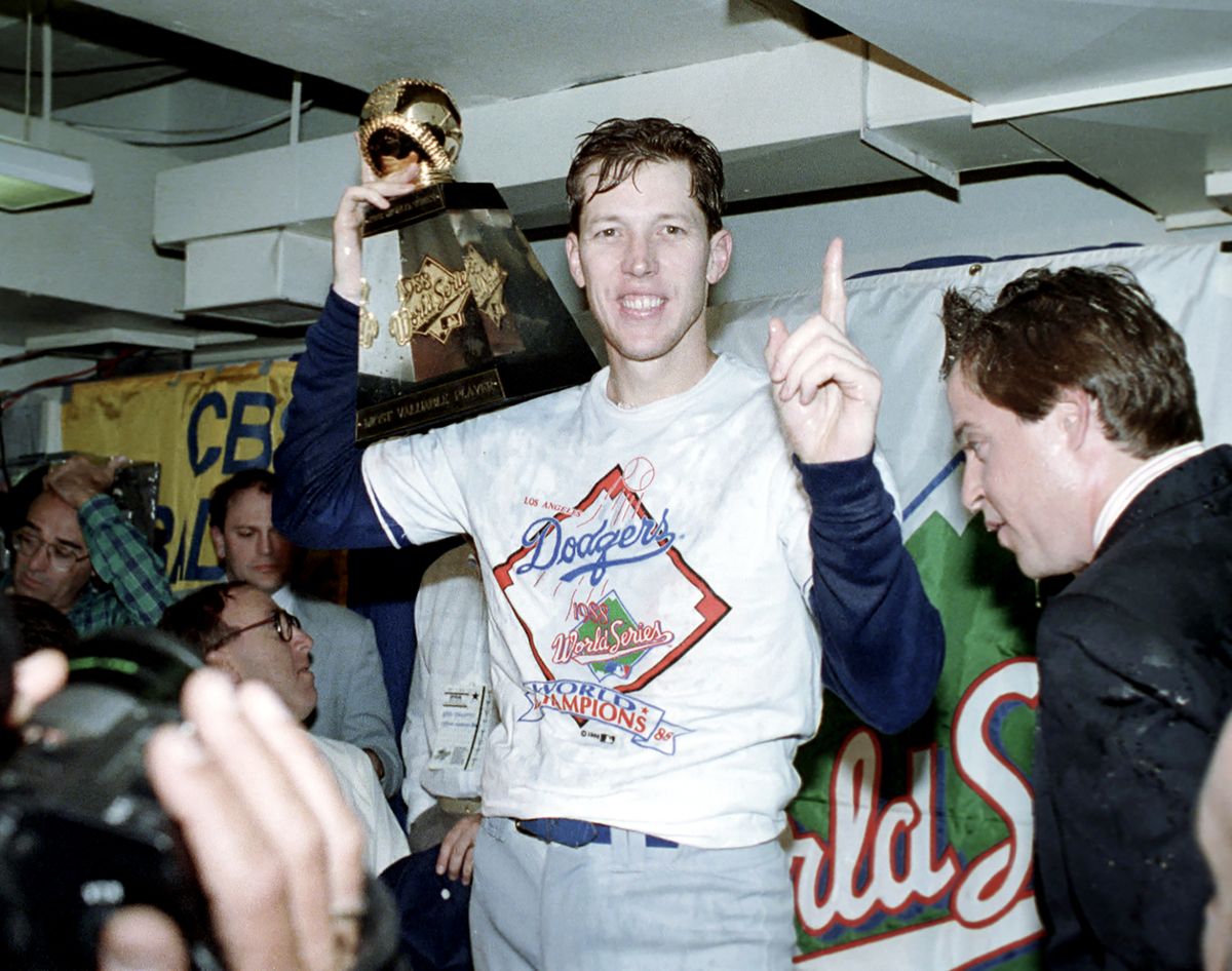 FILE – In this Oct. 20, 1988, file photo, Los Angeles Dodgers pitcher Orel Hershiser holds his World Series Most Valuable Player trophy following the Dodgers’ decisive 5-2 win over the Oakland Athletics in Oakland, Ca. Since Hershiser struck out Oakland’s Tony Phillips for the final out of the 1988 World Series, the Dodgers have played 5,014 regular-season games and 113 more in the postseason in pursuit of their next title. They have spent $3.69 billion in player payroll over 32 seasons. One more win and that elusive seventh championship will be theirs.  (Lennox Mclendon)