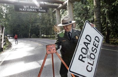 
Chief ranger Chuck Young removes the road closed sign at the Nisqually entrance to Mount Rainier National Park. 
 (Associated Press / The Spokesman-Review)