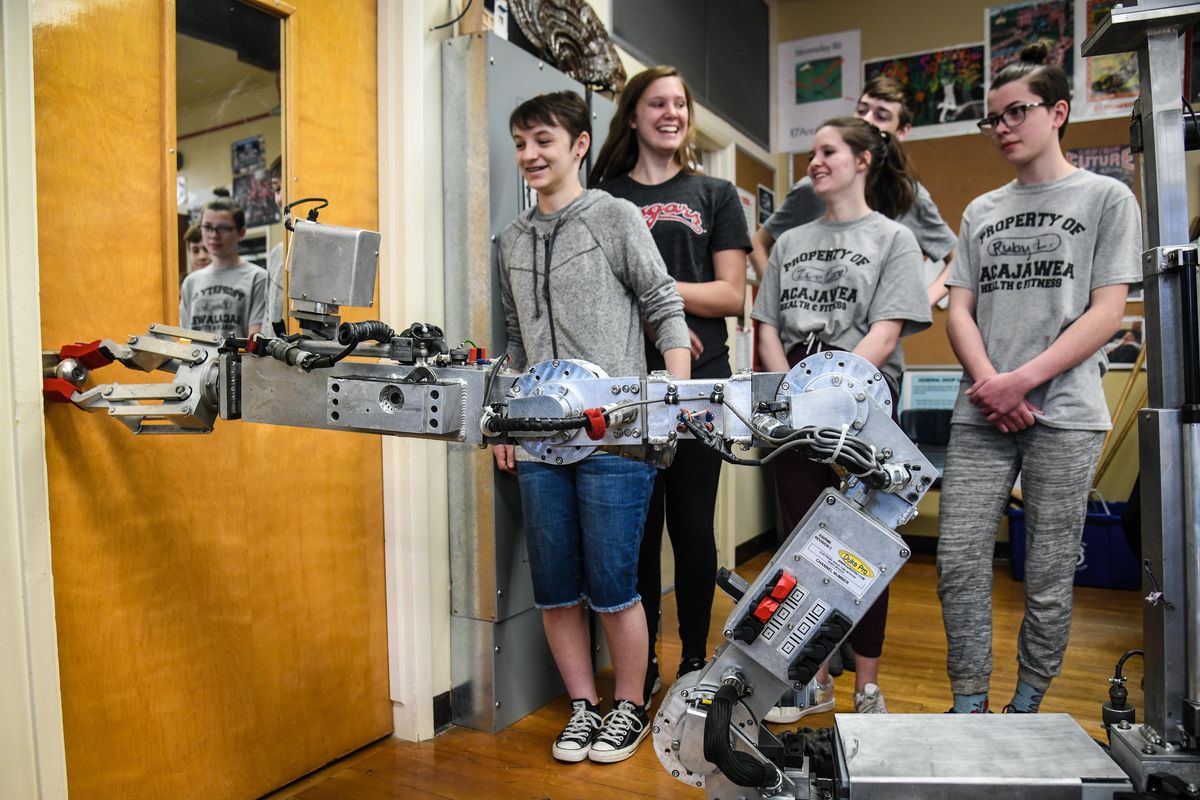 Sacajawea Middle School students in the Advanced Engineering class, from left, Kaitlyn Hawker, Brooklyn Jenson, Zoe Caro and Ruby Lannigan, designed and produced red gloves for the Spokane Police Department’s Andros F6B bomb robot. The new gloves proved their gripping ability on a door knob during a demonstration, Thursday, April 25, 2019, at the school. (Dan Pelle / The Spokesman-Review)