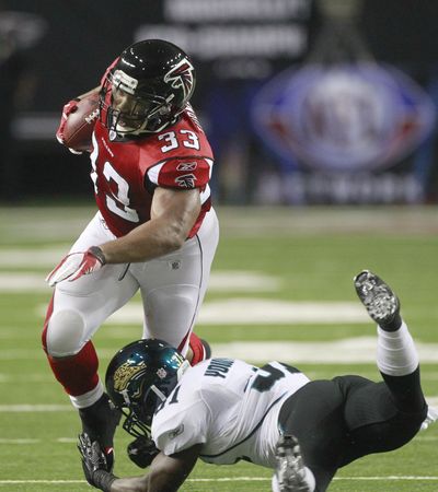 Falcons running back Michael Turner works against Ashton Youboty. (Associated Press)