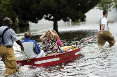 
Merrillville, Ind., firefighters Robert Harrell, left, and Kayvon Karimi help evacuate Jim and Gerda Holthausen, center, and their daughter Debbie Gehrig on Friday. Associated Press
 (Associated Press / The Spokesman-Review)