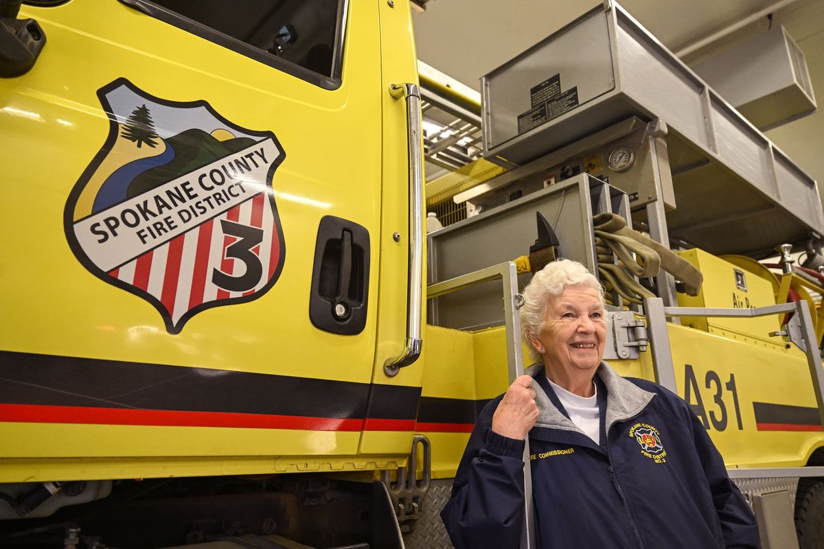 Sharon Colby, who rode on brush trucks as a younger woman, has been a fire commissioner at Spokane County Fire District 3 for decades. Colby, leaning against a truck at the Cheney station, is stepping down after more than 40 years in office in Spokane County.  (Jesse Tinsley/THE SPOKESMAN-REVIEW)
