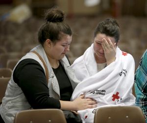 
Hannah Miles, right, sits with her sister Hailey after Hannah was reunited with her family in Roseburg, Ore., on Thursday, Oct. 1, 2015, after a deadly shooting at Umpqua Community College. (Andy Nelson/The Register-Guard via AP)