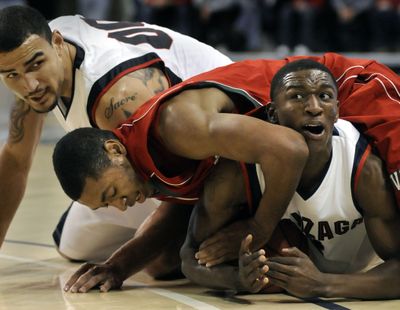 Gonzaga's Demetri Goodson tries to call time out as Mississippi Valley's #15 Shannon Behling ties up the ball in the 1st half, November 14, 2009 at the McCarthey Athletic Center. Zag's Robert Sacre (rear) also hits the floor. (Dan Pelle / The Spokesman-Review)
