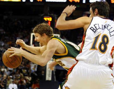 Sonics guard Luke Ridnour, left, gets tripped up by the Golden State Warriors' Marco Belinelli during the first half.Associated Press
(Associated Press / The Spokesman-Review)
