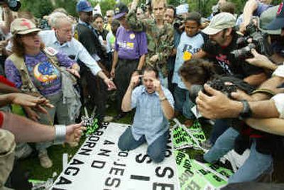 
A Boston resident becomes the focus of a scuffle on Boston Common on Sunday. A fight broke out when the man, carrying a sign with an anti-abortion message, interfered with an anti-war rally on the eve of the Democratic National Convention. 
 (Associated Press / The Spokesman-Review)