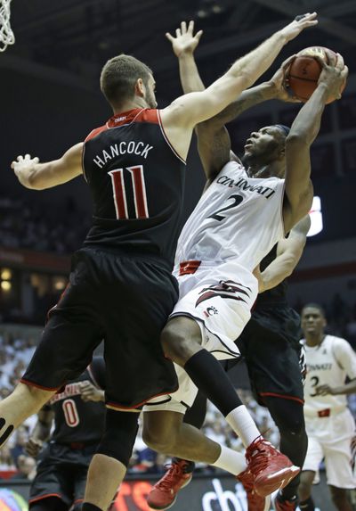 Louisville guard Luke Hancock, left, contests Cincinnati forward Titus Rubles’ shot. Hancock and the Cardinals topped the Bearcats 58-57. (Associated Press)
