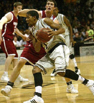 
Idaho forward Clyde Johnson drives past  Cougar forward Daven Harmeling. 
 (Associated Press / The Spokesman-Review)