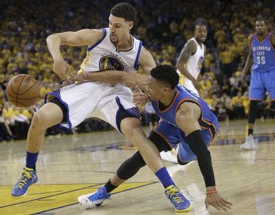 Warriors guard Klay Thompson, left, and Thunder guard Russell Westbrook reach for a loose ball during the first half of Game 5 on Thursday. (Marcio Jose Sanchez / Associated Press)
