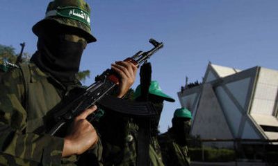 
Masked Hamas militants march past the Yamit Yashiva synagogue during a rally in the evacuated Jewish settlement of Neve Dekalim on Friday, celebrating the Israeli withdrawal from Gaza. 
 (Associated Press / The Spokesman-Review)