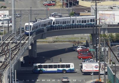 A Sound Transit light rail train passes over a Sound Transit bus on Wednesday.  (Associated Press / The Spokesman-Review)