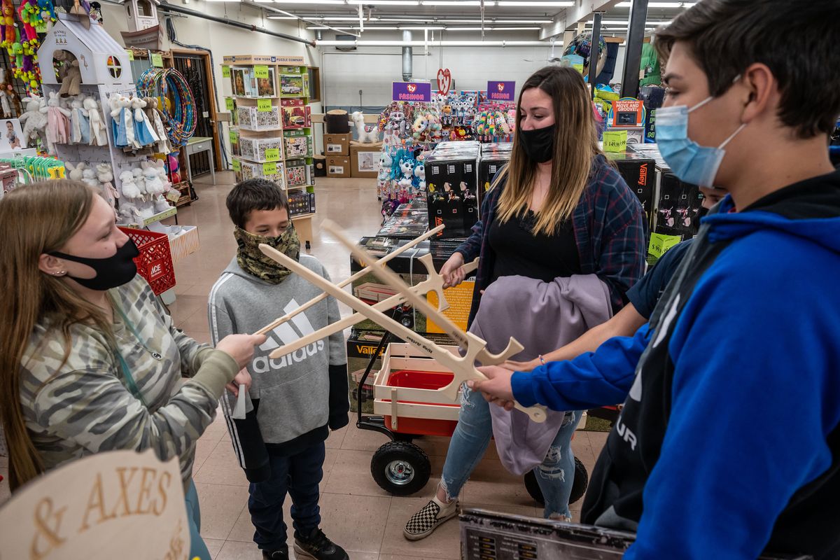 Briley Smith 13, left, Troy Carlon, Chloe Place and Thomas Place check out toy wooden swords during a free shopping spree at The General Store, Sat., Nov. 21, 2020. Last month The General Store did a “round up” fundraiser for the Pine City/ Malden children affected by the wildfires last summer. The proceeds were turned into gift cards for 54 Malden children to go on a shopping spree at The General Store this weekend.  (Colin Mulvany/THE SPOKESMAN-REVIEW)
