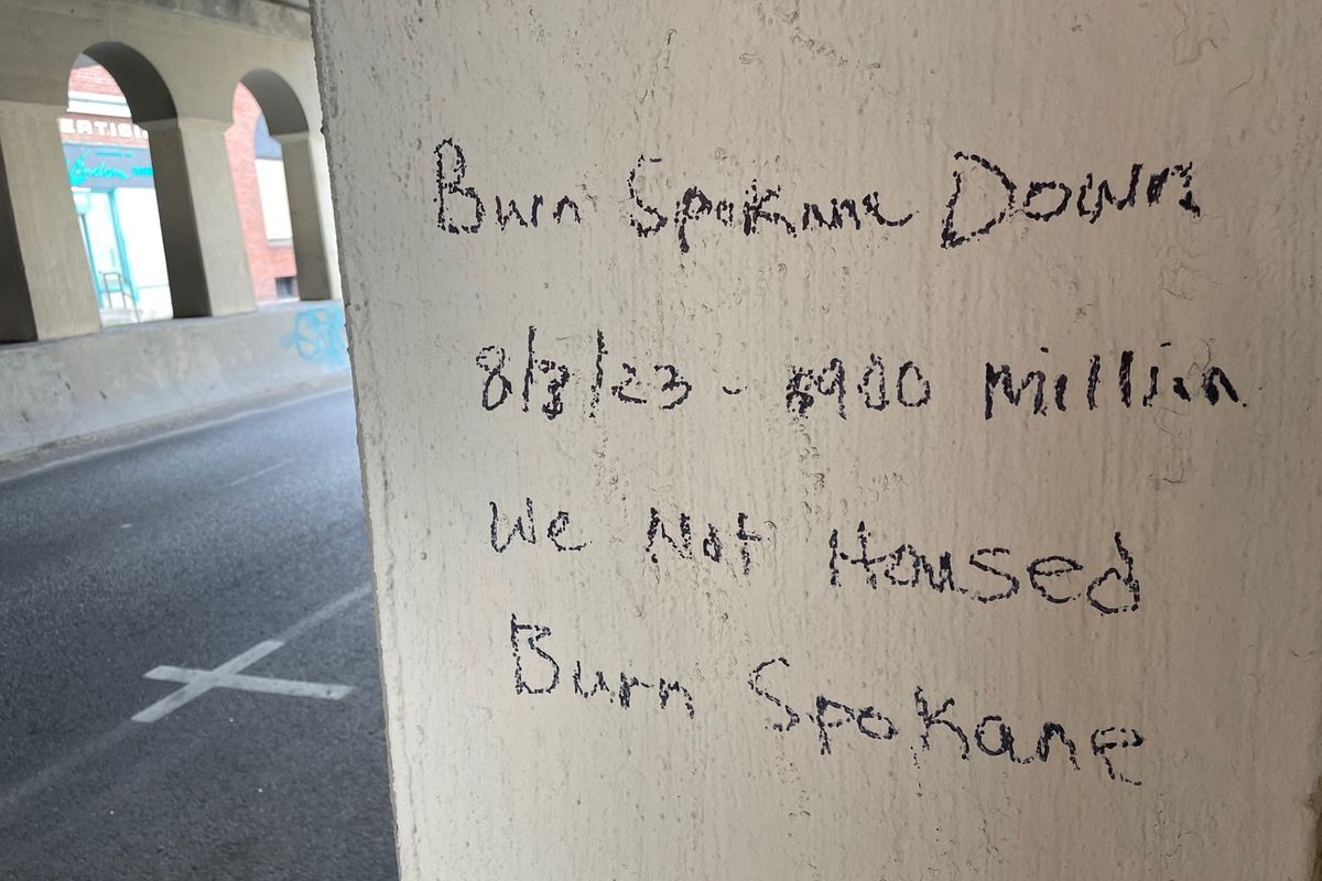 A “Burn Spokane Down” message can be read Aug. 4 under the railroad viaduct on Lincoln Street in downtown Spokane. Five fires started on the west side of the city on Aug. 3 afternoon, hours after the graffiti and other similar messages were reported to police.  (Garrett Cabeza / The Spokesman-Review)