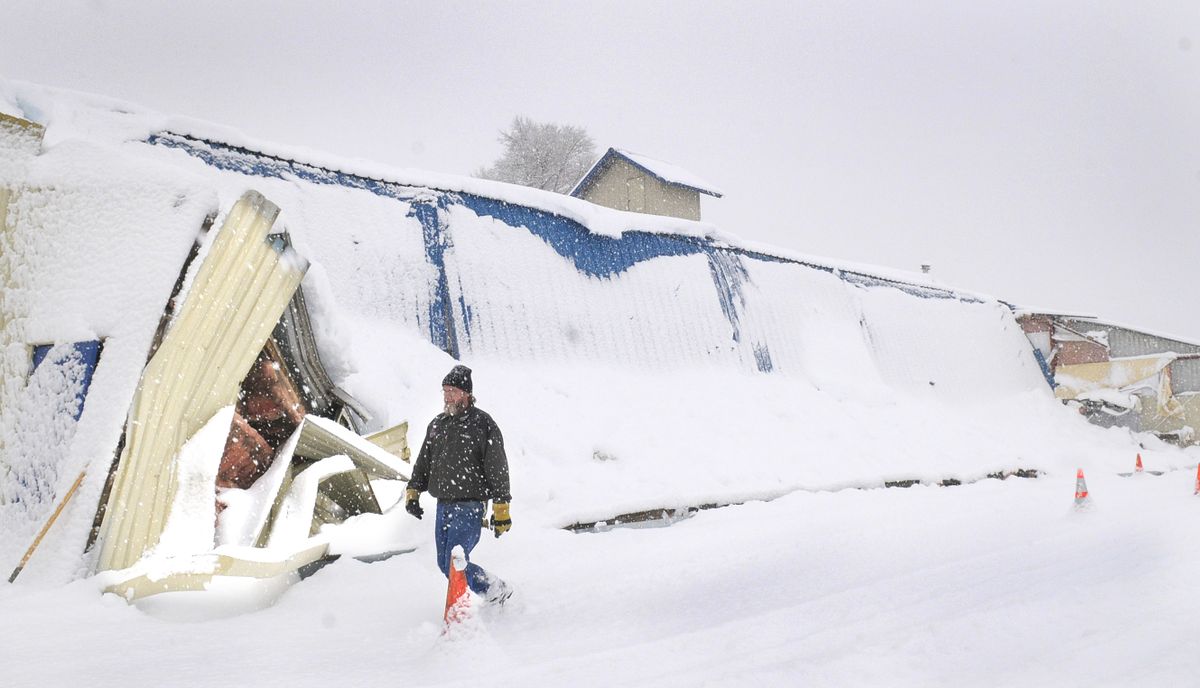 Craig Crocker, facilities manager for Spokane County Fair and Expo Center, walks past the collapsed roof of the Agriculture A Building on Monday.  (Christopher Anderson / The Spokesman-Review)