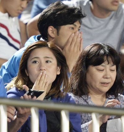 Japanese soccer fans react to a strong earthquake as they watch a match Saturday at BMW Stadium in Hiratsuka. (Associated Press)