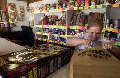 
Terri Hendrickx, of Tensed, Idaho, bags fireworks and chats with customers Thursday afternoon at Iron Mountain Fireworks along U.S. Highway 95 in Tensed. 
 (Jesse Tinsley / The Spokesman-Review)