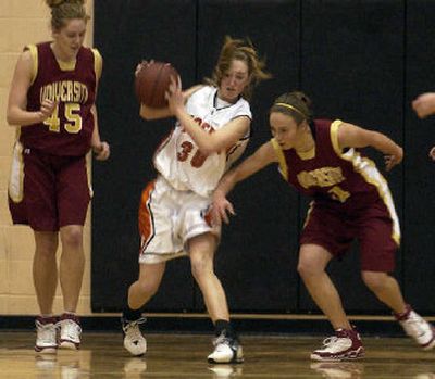 
Lewis and Clark High School's Lyndi Seidensticker, center, comes down with a rebound between two University High School defenders during league play last year. 
 (File / The Spokesman-Review)